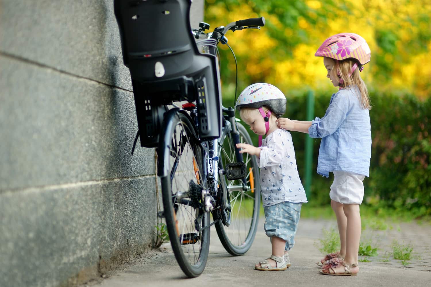Sisters with bike helmets getting ready for a ride
